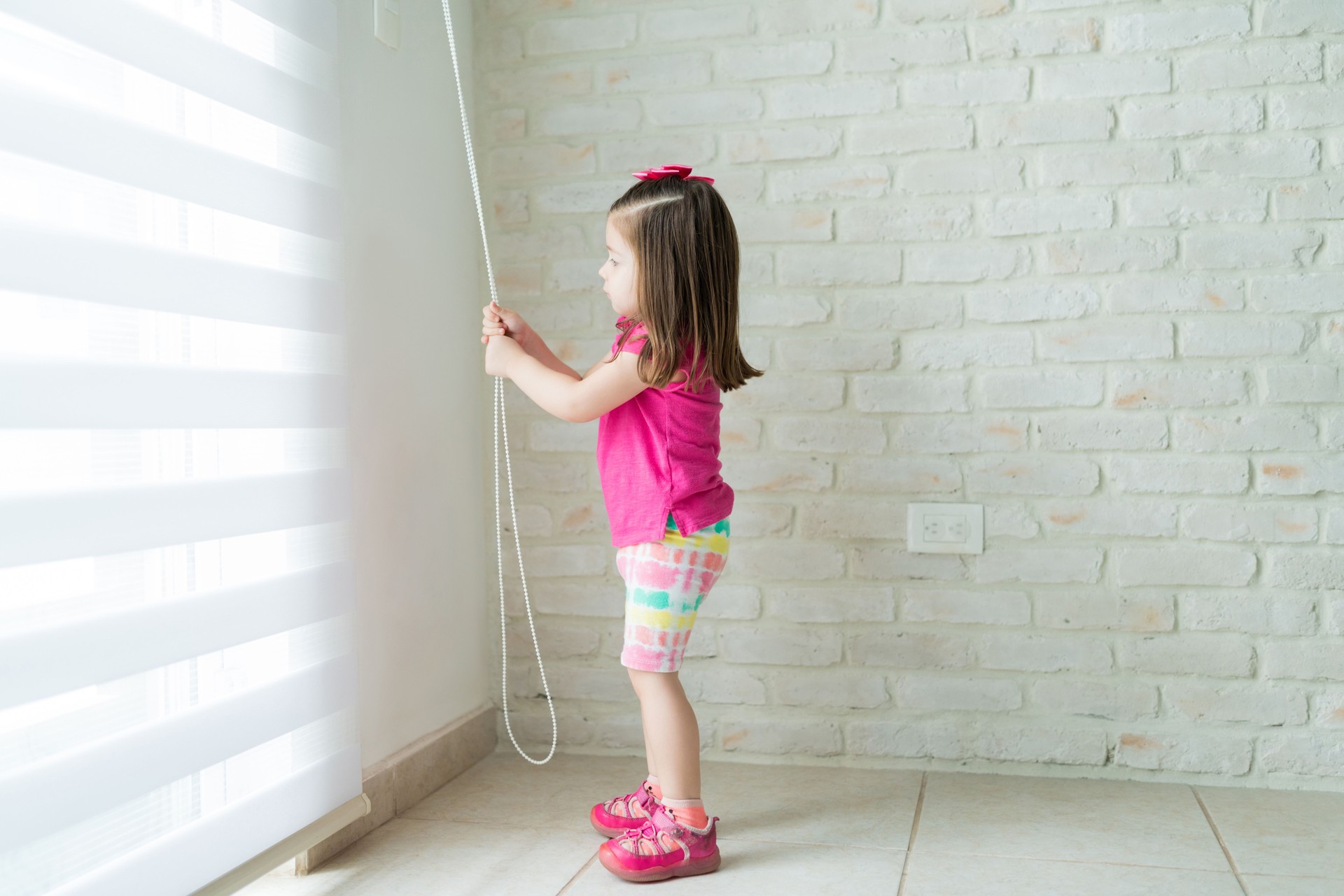 Little Toddler Opening Window In Living Room